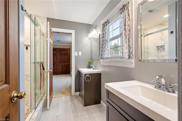 bathroom with two vanities, a sink, visible vents, and a marble finish shower