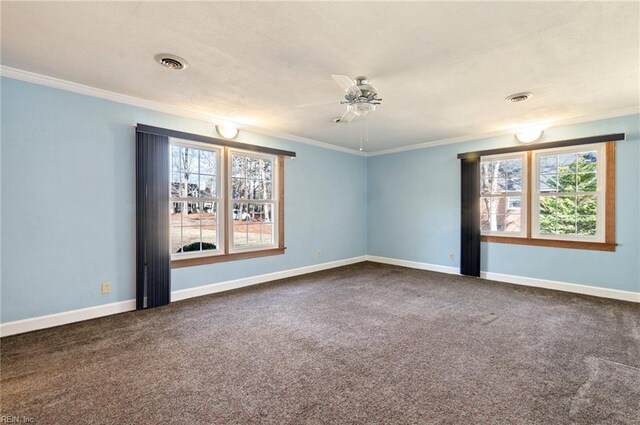 spare room with baseboards, visible vents, and crown molding