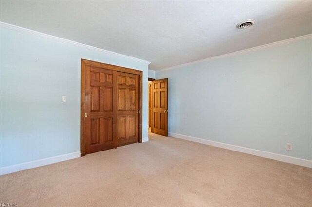 unfurnished bedroom with ornamental molding, light carpet, visible vents, and baseboards