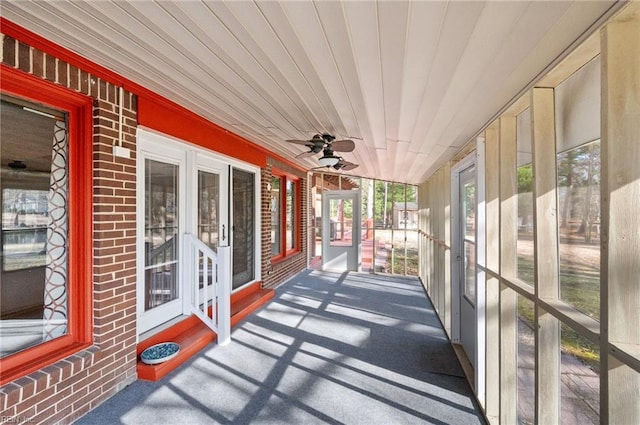 unfurnished sunroom with wood ceiling and ceiling fan