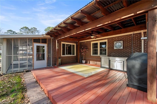 deck featuring a sunroom, ceiling fan, and grilling area