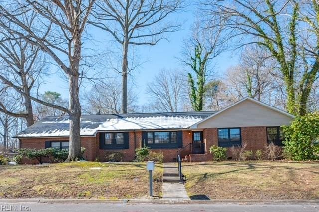 ranch-style house with a front yard and brick siding