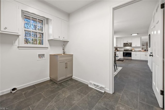 washroom with laundry area, baseboards, visible vents, washer hookup, and a sink