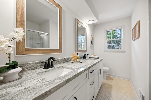 full bath with visible vents, a sink, toilet, and double vanity