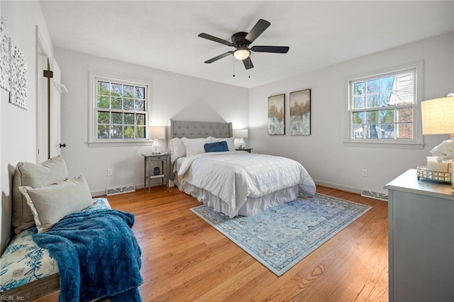 bedroom with light wood-style floors, multiple windows, and visible vents