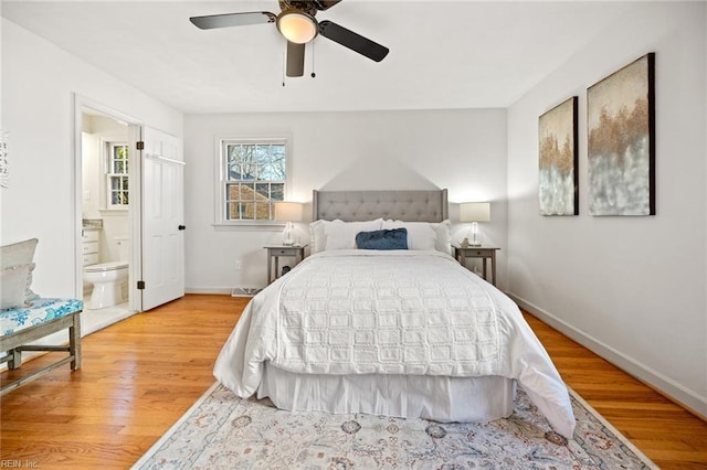 bedroom with light wood-style floors, a ceiling fan, baseboards, and ensuite bathroom