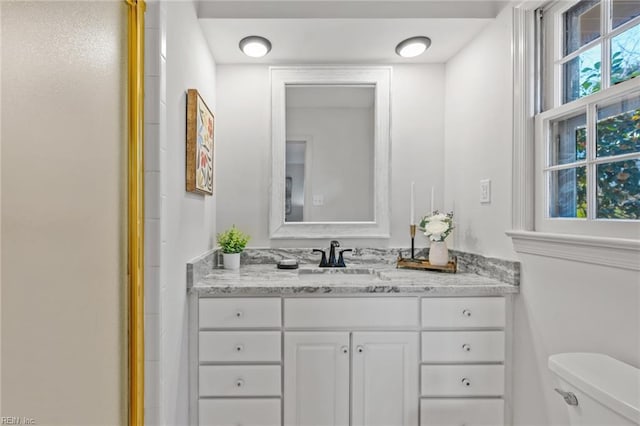 bathroom featuring toilet, an enclosed shower, and vanity