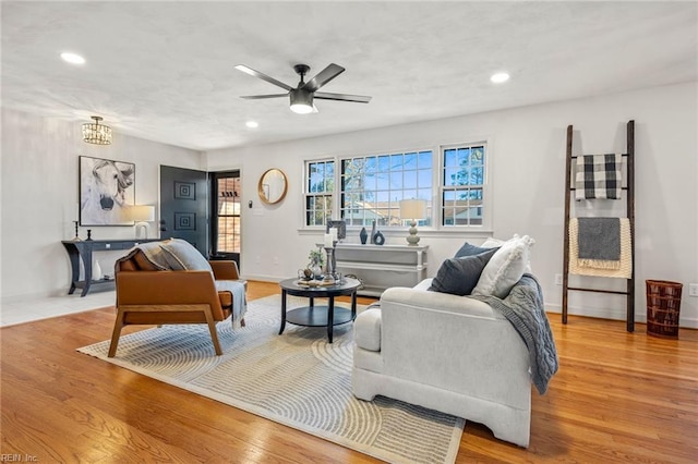 living room featuring light wood-type flooring, baseboards, and recessed lighting