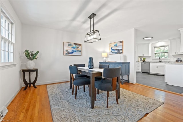 dining area with visible vents, baseboards, and wood finished floors