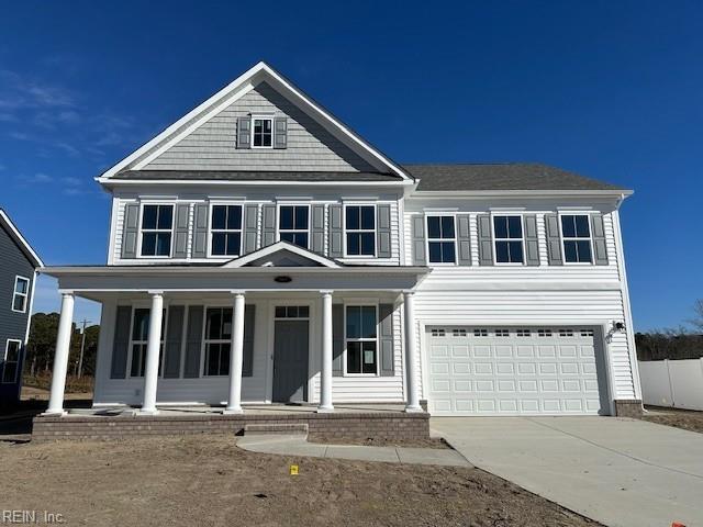 view of front of home with covered porch, driveway, an attached garage, and fence