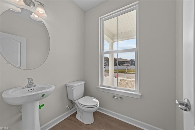 bathroom featuring toilet, baseboards, and wood finished floors