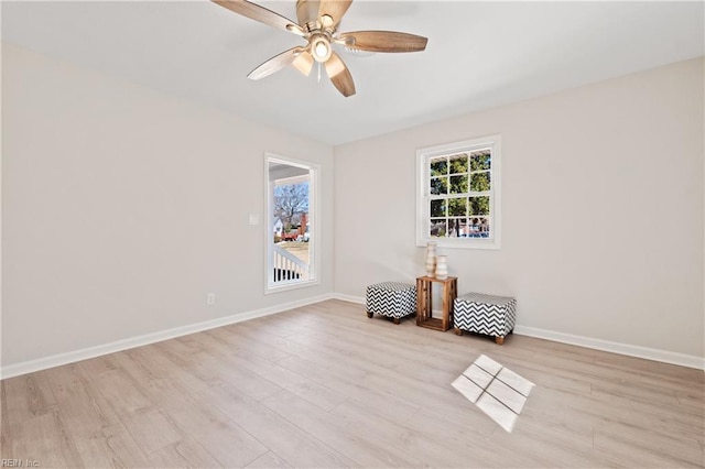 unfurnished room with light wood-style floors, baseboards, and a ceiling fan