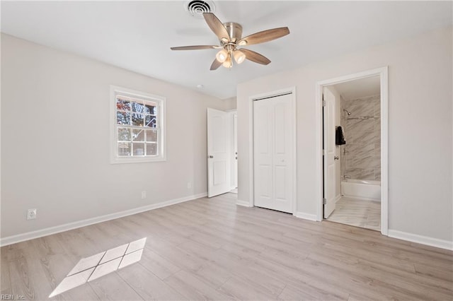 unfurnished bedroom with baseboards, visible vents, ensuite bathroom, light wood-type flooring, and a closet