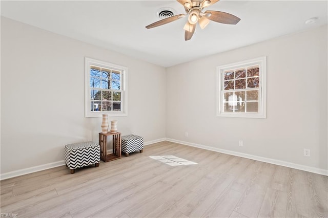 unfurnished room with light wood-style floors, visible vents, and baseboards