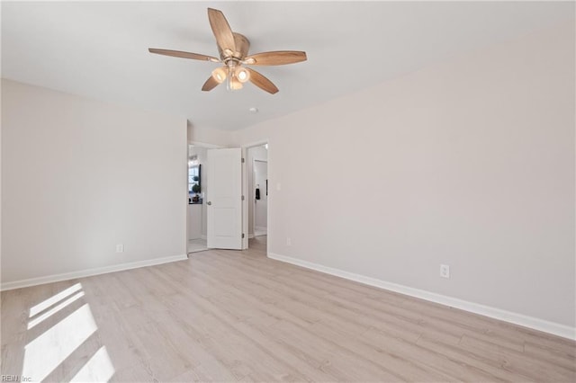 spare room with light wood-type flooring, ceiling fan, and baseboards