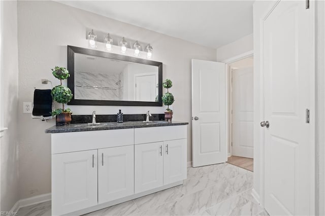 full bathroom with marble finish floor, double vanity, and a sink