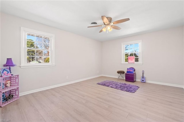 game room featuring a ceiling fan, light wood-type flooring, visible vents, and baseboards