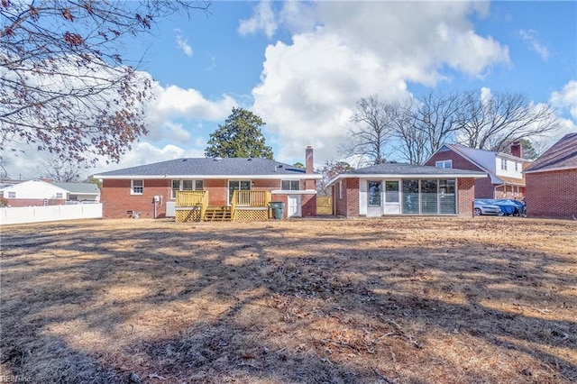 rear view of house with brick siding, fence, and a chimney