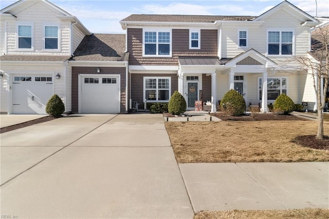 view of front of house with a shingled roof, concrete driveway, metal roof, a garage, and a standing seam roof