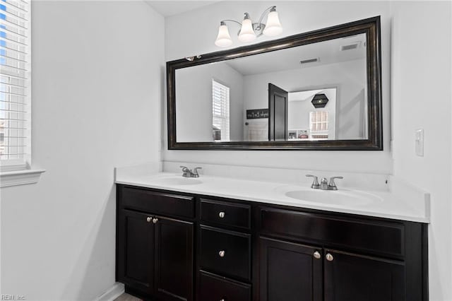 full bathroom featuring double vanity, visible vents, and a sink