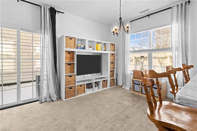 carpeted living room featuring a chandelier and visible vents