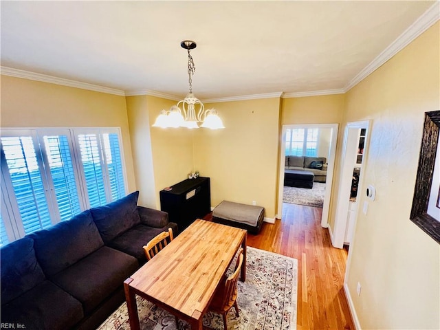 living room featuring light wood-type flooring, crown molding, and baseboards