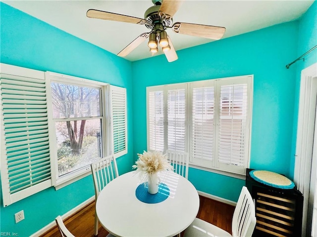 dining area with baseboards, a ceiling fan, and wood finished floors