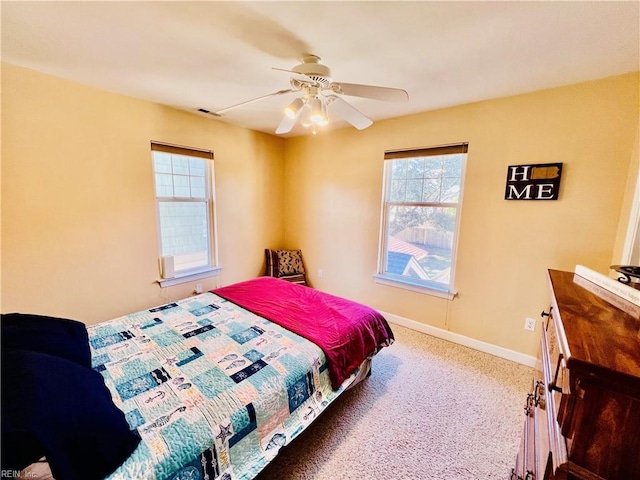 carpeted bedroom featuring visible vents, baseboards, and ceiling fan