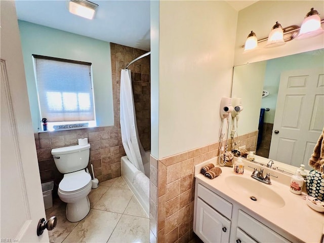 bathroom featuring tile walls, toilet, shower / tub combo, wainscoting, and vanity