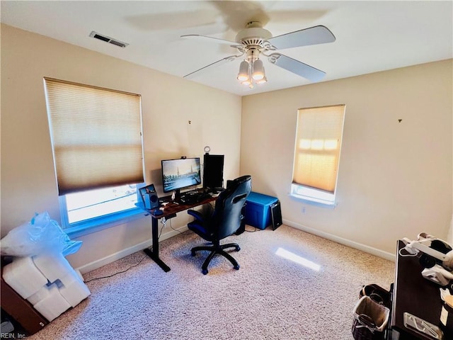 office space featuring carpet, visible vents, ceiling fan, and baseboards