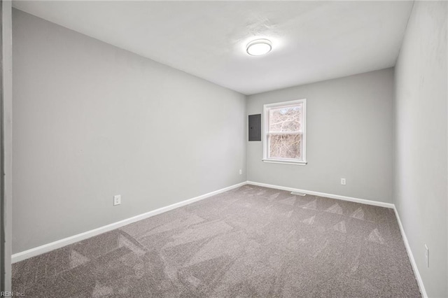 carpeted empty room with electric panel and baseboards