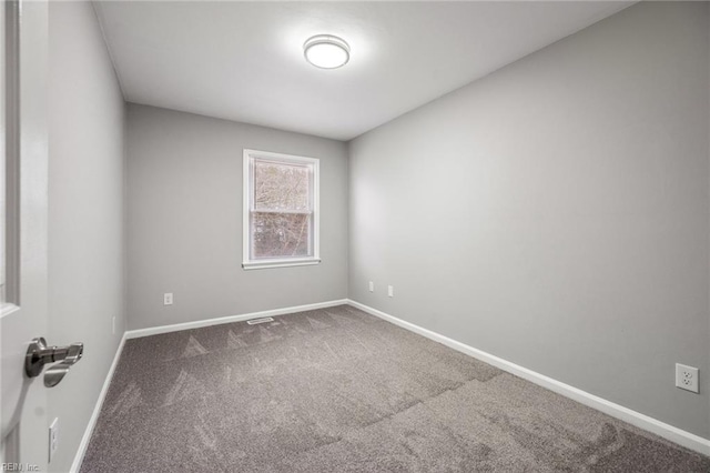 unfurnished room featuring carpet and baseboards