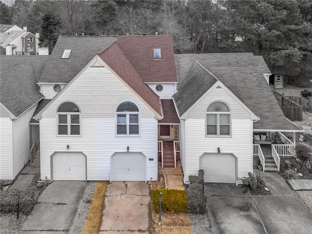 view of front of home featuring driveway, roof with shingles, and an attached garage