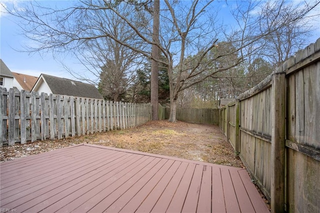 wooden terrace with a fenced backyard