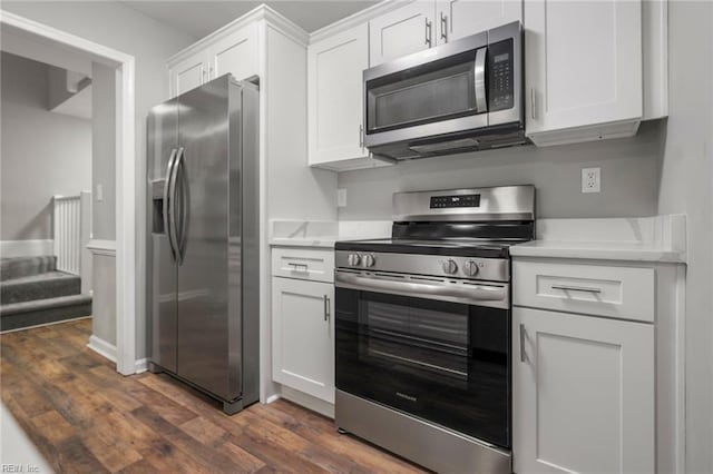 kitchen featuring dark wood-style floors, appliances with stainless steel finishes, white cabinets, and light countertops