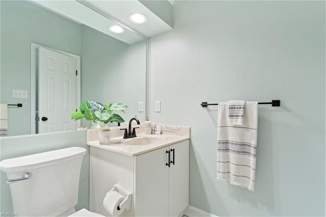 half bath with toilet, recessed lighting, and vanity