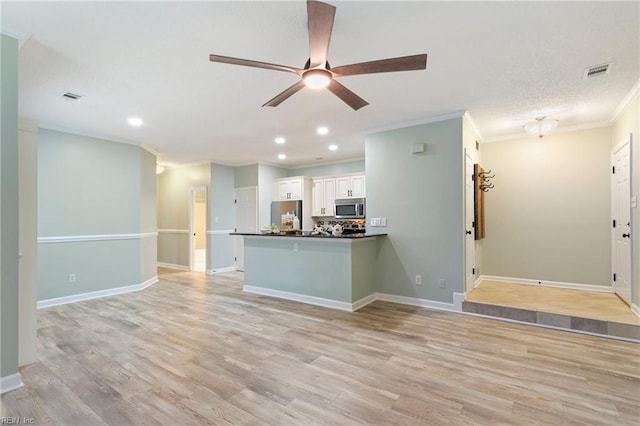 unfurnished living room featuring ornamental molding, light wood-type flooring, and visible vents