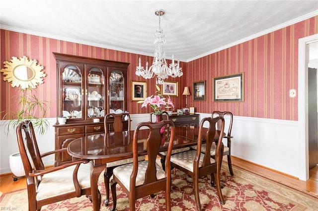 dining room featuring a notable chandelier, light wood-type flooring, and wallpapered walls