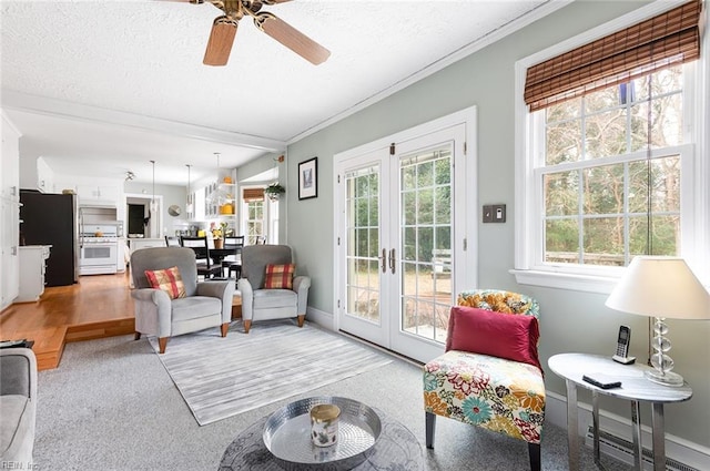 living room with a textured ceiling, light carpet, baseboards, french doors, and crown molding