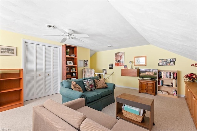 living room with lofted ceiling, a ceiling fan, visible vents, and light colored carpet