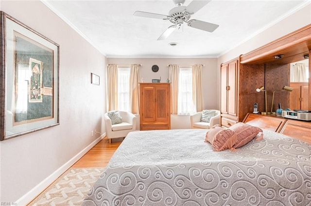 bedroom featuring light wood finished floors, ornamental molding, visible vents, and baseboards