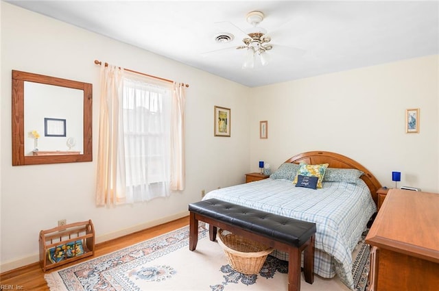 bedroom with visible vents, baseboards, and wood finished floors