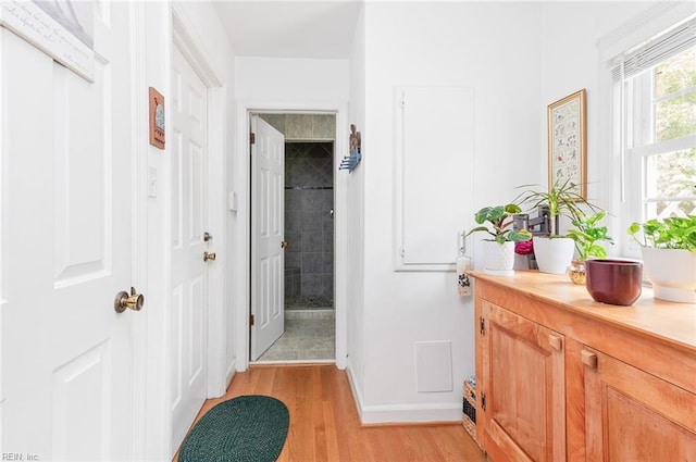 hallway with light wood-type flooring and baseboards