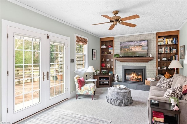 living area featuring carpet, french doors, crown molding, a brick fireplace, and a textured ceiling