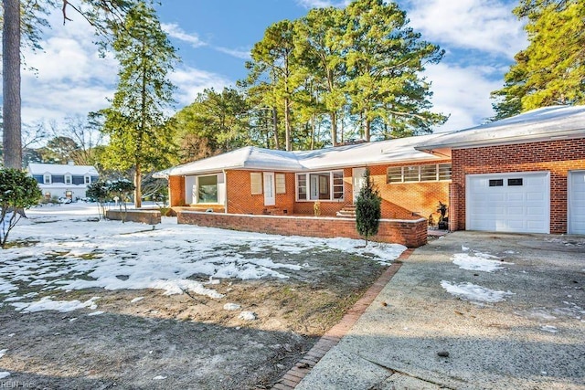 ranch-style home with brick siding, driveway, and an attached garage