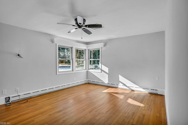 spare room with a baseboard radiator, a ceiling fan, and wood finished floors