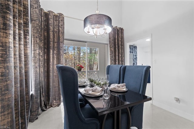 dining room featuring light tile patterned floors, baseboards, and a notable chandelier