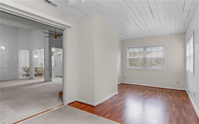 spare room with ceiling fan, dark wood-type flooring, visible vents, and a healthy amount of sunlight