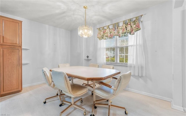 dining room featuring a chandelier, light wood-style flooring, and baseboards