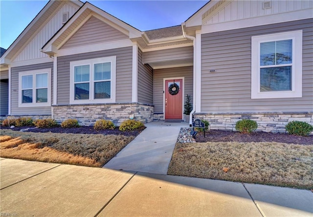 property entrance with stone siding and board and batten siding